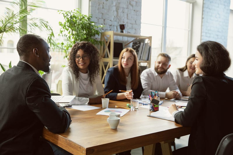 A group of young diverse professionals sitting around a table having a meeting